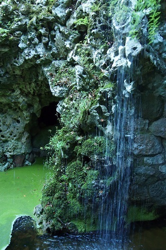 Waterfall and green pool at Quinta da Regaleira in Sintra, Portugal